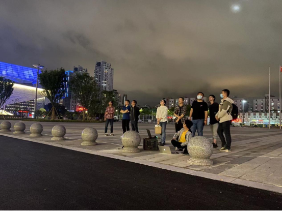 石瑶（左四）与团队对亚运场馆夜景照明进行最后调试。